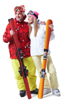 Portrait of happy couple with skis in hands looking aside with smiles