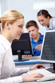 Image of secretary typing document on the background of working people