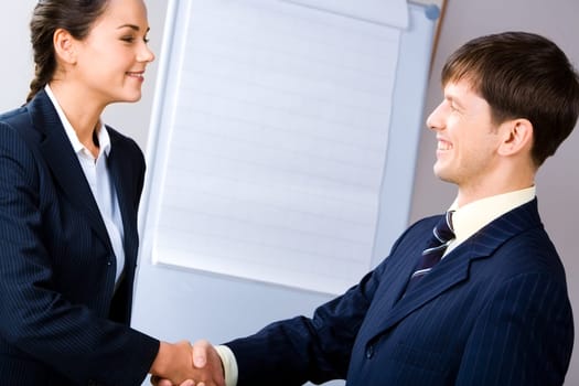 Business people shaking hands making an agreement on the background of whiteboard