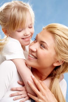 Portrait of little daughter embracing her mother and looking at her