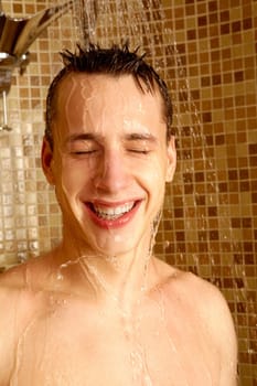 Portrait of happy guy laughing while taking shower