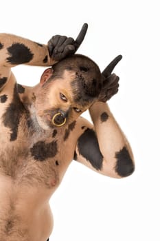 Portrait of man with body painting looking like bull over white background