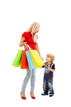 Image of pretty female holding bags full of presents or shoppings with her son near by