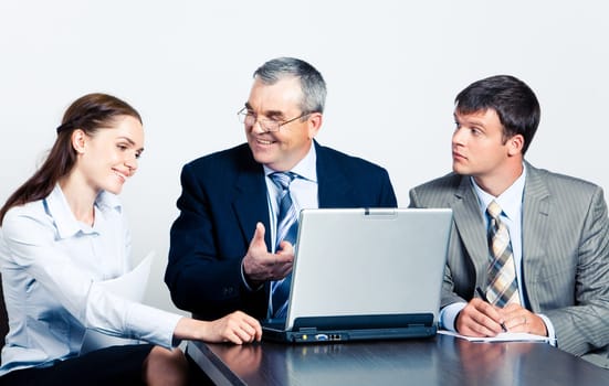 Communication of elderly boss with his managers in front of laptop at business meeting