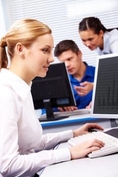 Image of secretary typing on the background of working colleagues