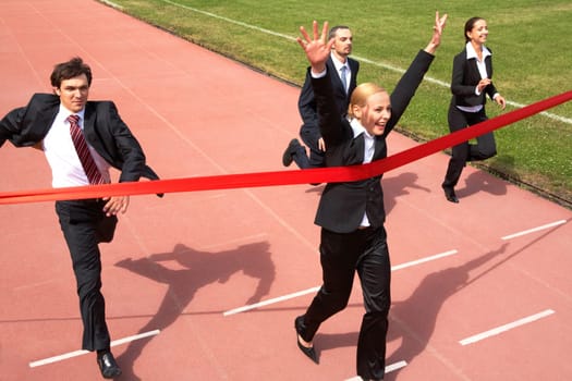 Photo of happy businesswoman crossing finish line during race