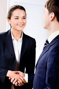 Portrait of confident woman looking at her business partner while handshake