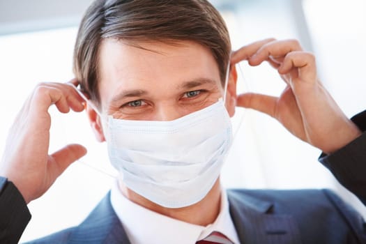 Portrait of businessman with protective mask going to put it on