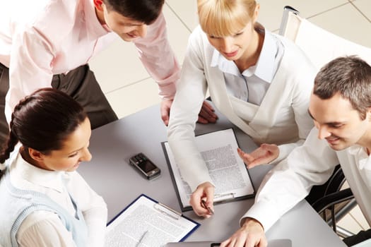 Above view of friendly workteam discussing business papers
