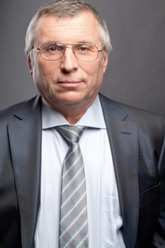Photo of senior employer looking at camera on black background