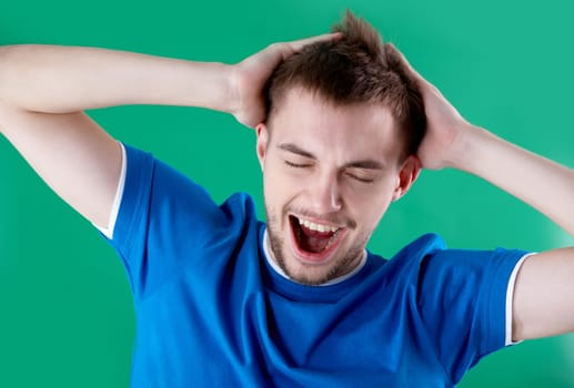 Portrait of young man full of joy over green background