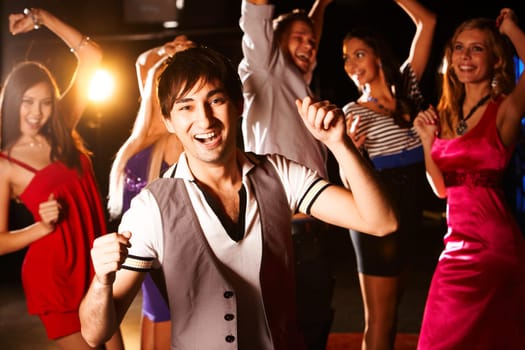 Portrait of energetic dancer on background of happy friends having fun
