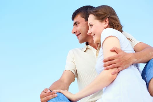 Photo of peaceful couple looking forward with blue sky on background
