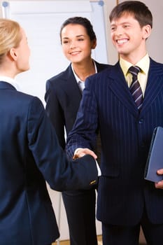 Image of confident business people shaking hands at meeting