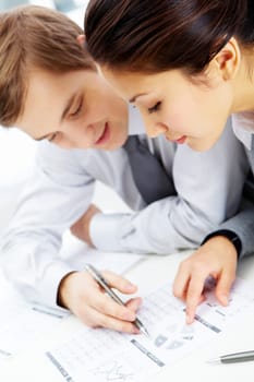 Successful businessman and his pretty colleague discussing papers