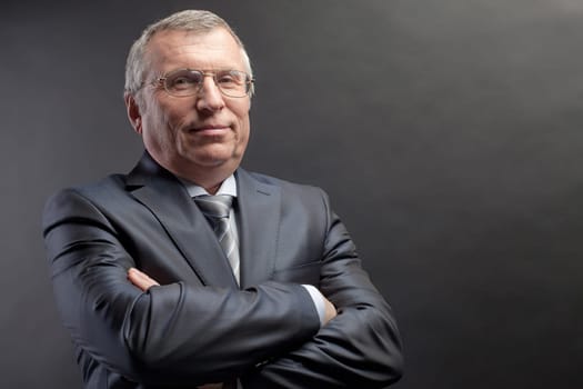 Photo of senior employer looking at camera on black background