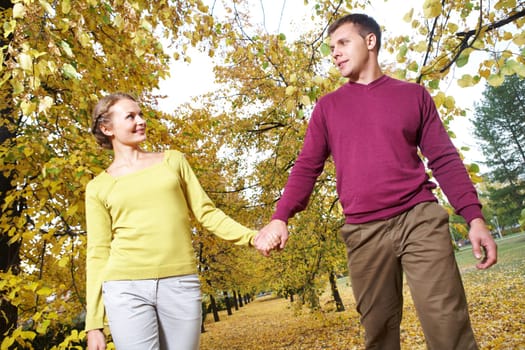 Portrait of couple walking in autumn holding hands