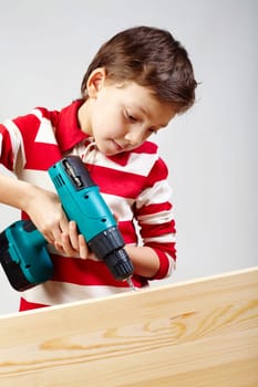 Portrait of drilling boy in workshop