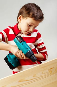 Portrait of drilling boy in workshop