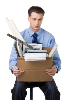 Portrait of businessman holding box with documents sitting on the chair