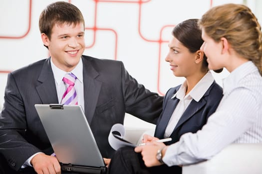Business team of three people discussing a new project in room