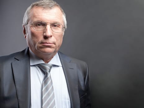 Photo of senior employer looking at camera on black background