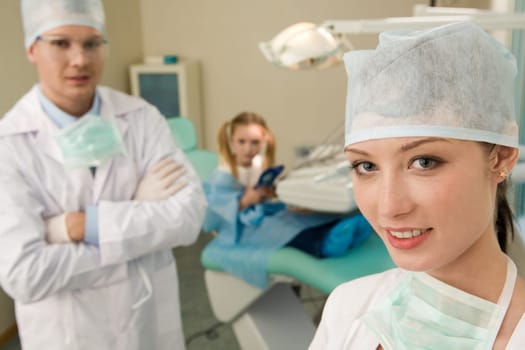 Portrait of pretty assistant looking at camera in dentistry office