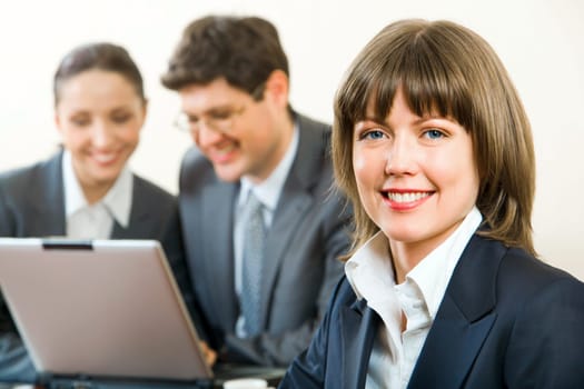 Portrait of smiling businesswoman on the background of two businesspeople