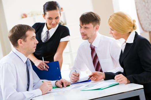 Serious business partners looking at their boss explaining new plan