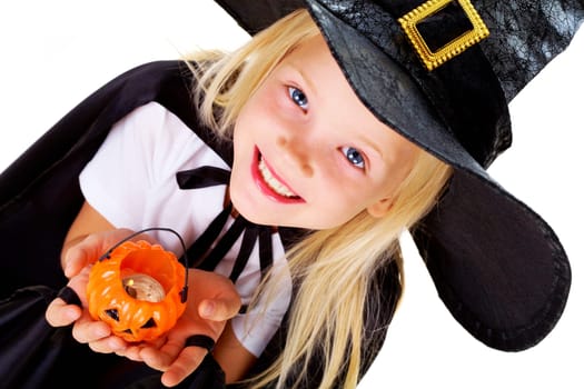 Portrait of girl in witch costume and small pumpkin candle in hands