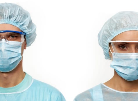 Two surgeons in masks isolated on white