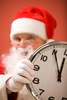 Photo of clock showing five minutes to midnight with Santa on background