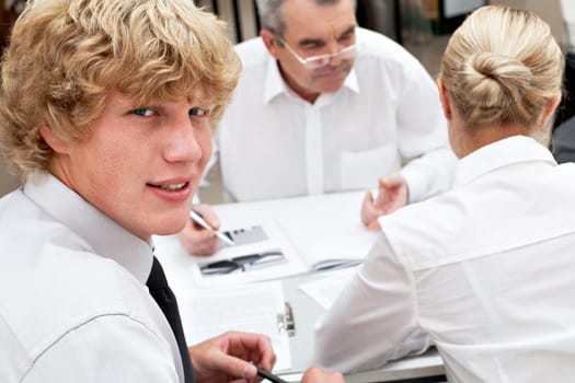 Image of friendly businessman looking at camera during business meeting
