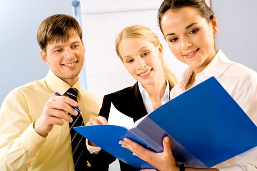 Portrait of three business persons reading a document together