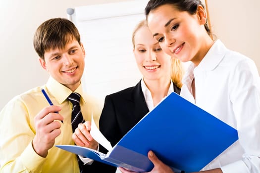 Portrait of successful business people looking at document in the office