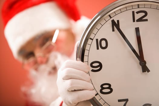 Photo of clock showing five minutes to midnight with Santa on background