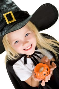 Portrait of girl in witch costume and small pumpkin candle in hands