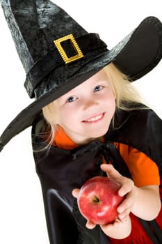 Portrait of girl in witch costume and red apple in hands