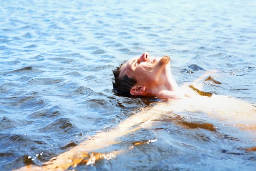 Delighted guy bathing in water and enjoying it