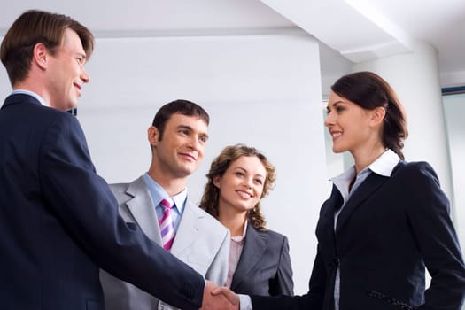 Image of businessman and woman shaking hands at meeting