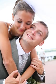 Portrait of affectionate bride embracing tenderly her husband during wedding