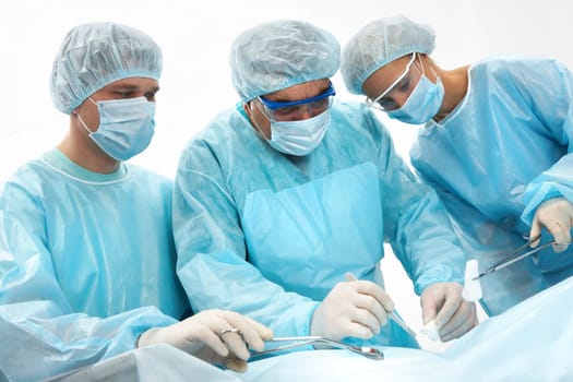 Three surgeons operating on a patient