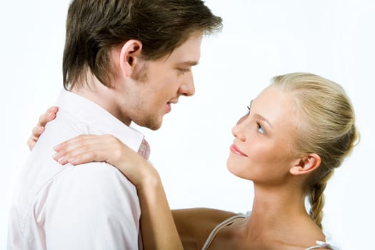 Handsome guy looking at pretty blonde who keeping her hands on his shoulders