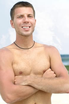 Portrait of a shirtless man with crossed arms looking at camera
