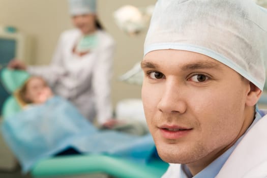 Face of successful clinician in uniform looking at camera in his workshop