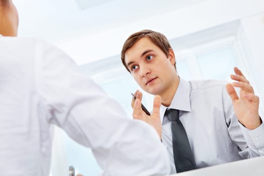 Smart businessman explaining something to his colleague in office
