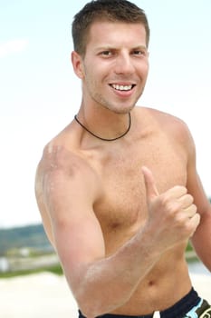 Portrait of a shirtless man showing big thumb