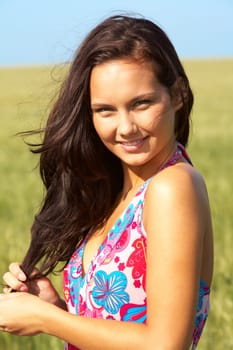 Photo of pretty girl in colorful dress looking at camera on sunny day