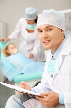 Portrait of a stomatologist against a nurse and a patient