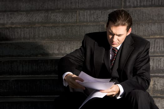 Portrait of unhappy businessman reading the document
